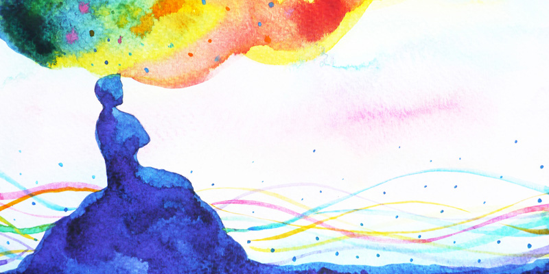 abstract image of person sitting on hill with colours floating around them
